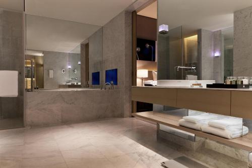 台北台北寒舍艾美酒店 的一间带水槽、浴缸和镜子的浴室