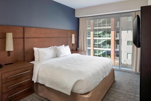 格林维尔Residence Inn by Marriott Greenville Downtown的一间卧室设有一张大床和一个大窗户