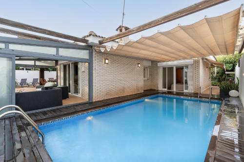 坎布里尔斯"Charm & Cozy 4BR - 3BA with Pool & Barbecue"的一座房子里带凉棚的游泳池