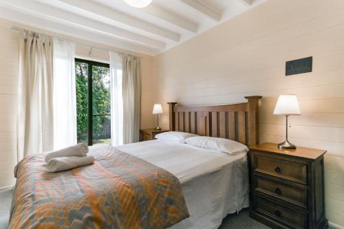 温特沃斯瀑布阿卡迪亚小屋的一间卧室设有一张大床和一个窗户。
