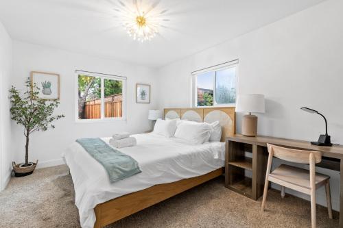 圣何塞@ Marbella Lane - Fresh and Vibrant 3BR Home的一间卧室配有一张床、一张桌子和一把椅子