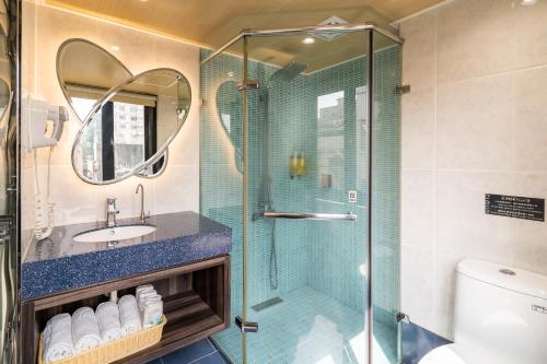 高雄云端精致旅馆的一间带玻璃淋浴和水槽的浴室