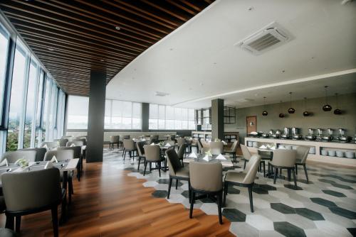 PinelengRogers Hotel Manado的用餐室设有桌椅和窗户。
