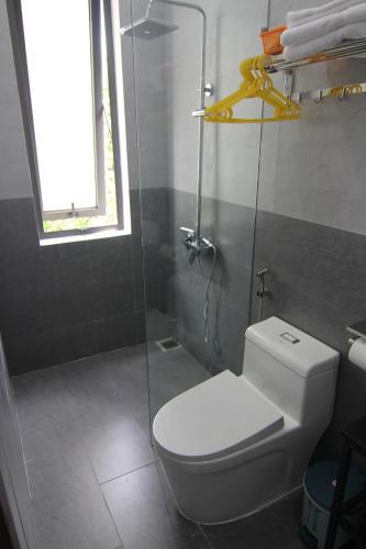 顺化Dory Homestay的一间带卫生间和玻璃淋浴间的浴室