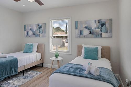 西棕榈滩West Palm Beach Tropical Oasis的一间卧室设有两张床和窗户。