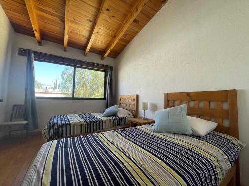 特基斯基亚潘Casa Angeles Centro de Tequisquiapan para 6 personas的带窗户的客房内的两张床