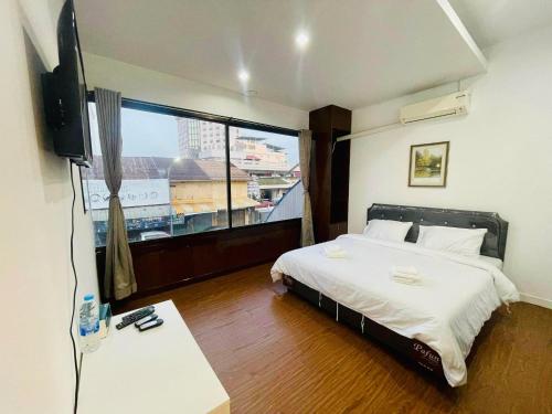 合艾Lamoon Hostel的一间卧室设有一张床和一个大窗户