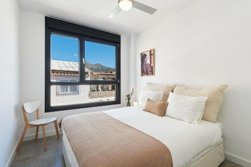 马拉加Solaga - Jabega的白色的卧室设有一张大床和一个窗户
