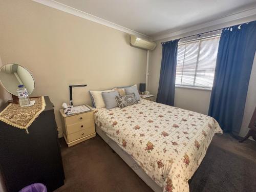 珀斯Joondalup Guest House的一间卧室配有一张床、镜子和窗户