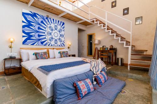穆克缇斯瓦SHIVAYA since 1953的一间带大床和楼梯的卧室