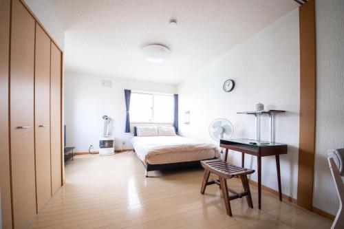 小樽Sumiyoshi House Room B的卧室配有1张床、1张桌子和1把椅子