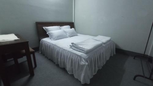 芹苴Enjoy Mekong Hostel的一间卧室配有带白色床单和枕头的床。