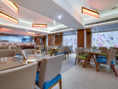 海得拉巴ZIBE Hyderabad by GRT Hotels的餐厅内带桌椅的用餐室