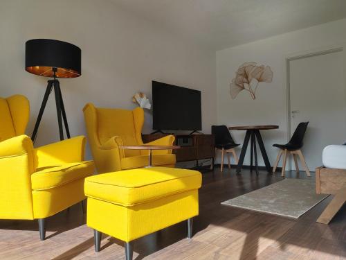皮尔纳Ferienwohnung Elbtraum的客厅配有黄色椅子和电视
