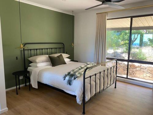 The RangeKidman's Rest的一间卧室设有一张带绿色墙壁和窗户的床。