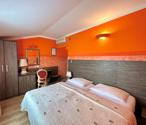 塞扎纳格瑞霍尔迪潘德恩斯酒店的一间卧室设有一张大床和橙色的墙壁