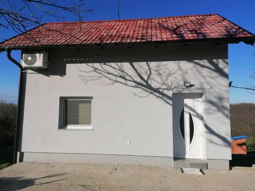 伊洛克Kuća za odmor Kustura的白色的房子,有窗户和红色屋顶
