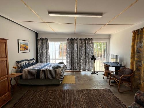 肯普顿帕克Firefly Budget Friendly Guest House的一间卧室配有一张床、一张书桌和一个窗户。