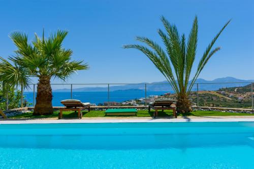 伊罗达Villa Calypso Elounda的一个带2张长椅的海景游泳池