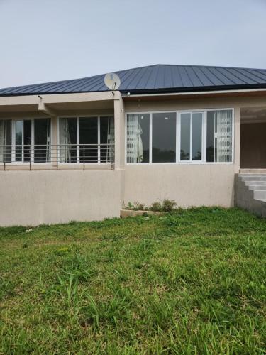 3 Bedroom Serene home In Kwahu的一座带太阳能屋顶和庭院的房子
