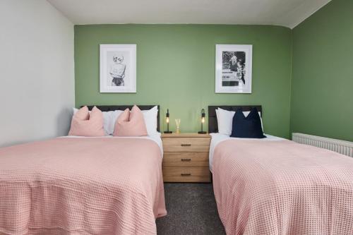 达灵顿Stunning House wParking Sleeps7的绿墙客房内的两张床