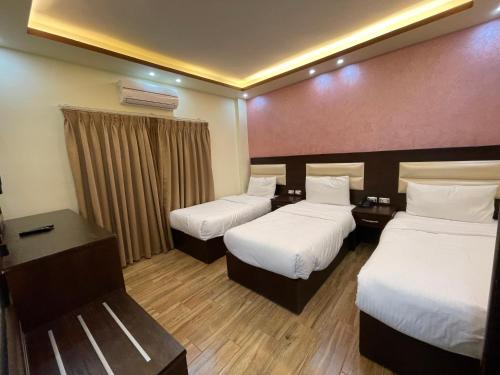 瓦迪穆萨Petra Sofsaf Hotel的酒店客房设有两张床和窗户。