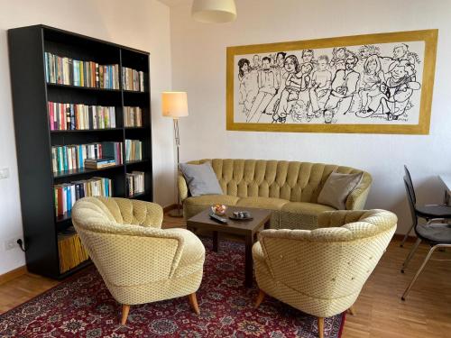 施特拉尔松德斯卓尔森德旅馆的客厅配有沙发、两把椅子和一张桌子