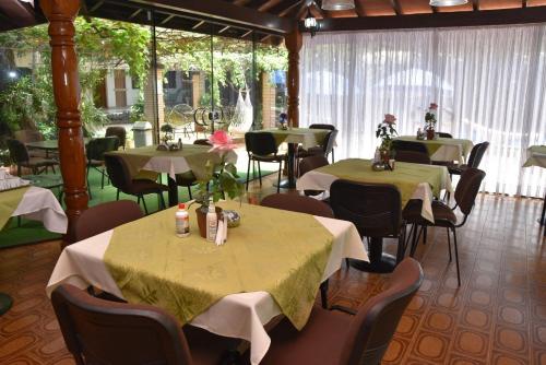 恩卡纳西翁亚瑟香巴拉酒店的餐厅配有桌椅和绿色桌布