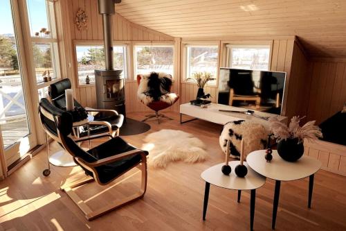 莫斯费德斯拜尔Paradise near Reykjavik w. Sauna - Northern Lights的客厅配有椅子、沙发和电视
