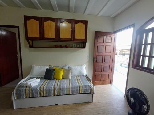 萨夸雷马LAGOA I - Saquarema RJ的一间卧室配有一张带黄色枕头的床和一扇门
