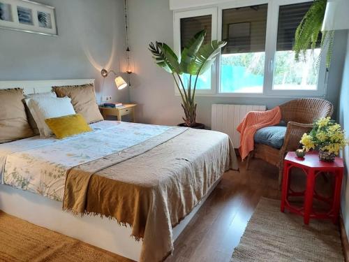 希洪precioso chalet的卧室配有床、椅子和窗户。