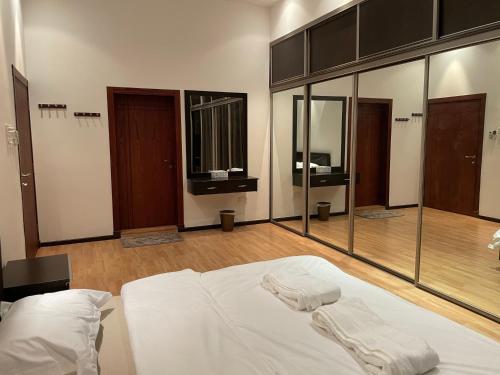 麦纳麦Premium 2 Bedroom Flat的玻璃墙客房内的一张白色床