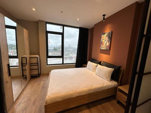 卡特佩Bureau residence的一间卧室配有一张带白色床单和窗户的床。
