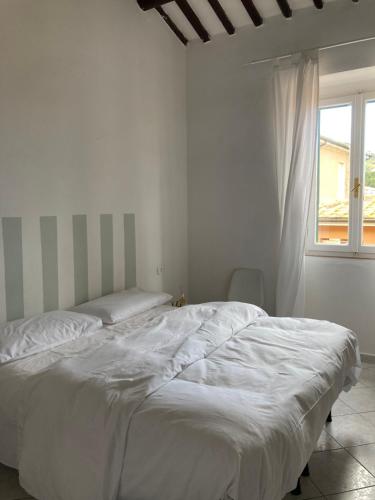 马西亚娜马里纳La casina的白色的窗户客房内的一张白色的床