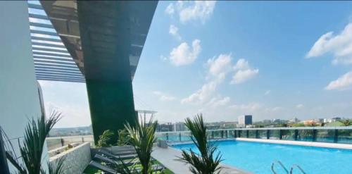 阿克拉Luxury 2 Bedroom Apartment with Huge Balcony , Pool, Gym at Tribute House的享有大楼顶部游泳池的景色
