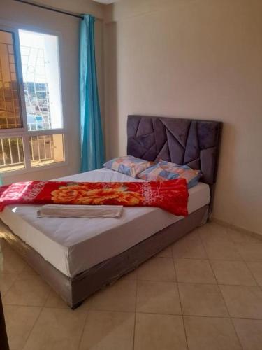 Zemmour TouirzaIBRAHIM BOUHOU的一间卧室配有一张床铺,床上铺有红色毯子