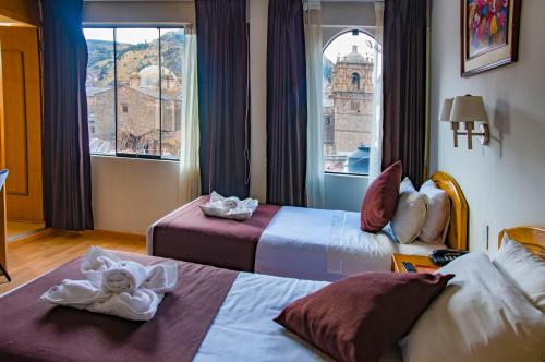普诺Casona Plaza Balsa Inn的酒店客房设有两张床和窗户。