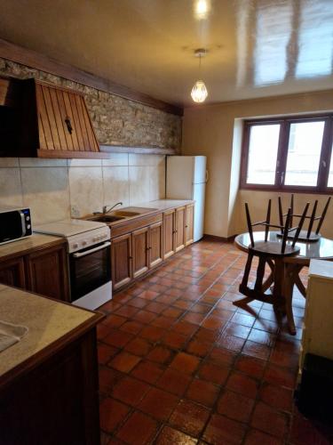 克莱尔沃雷拉克hypercentre meublé的厨房配有桌子和炉灶。 顶部烤箱