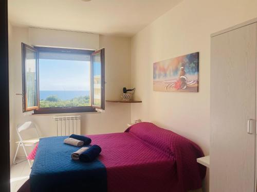 阿尔盖罗Voce Del Mare - sea view- Alghero Airport的一间卧室设有紫色的床和窗户