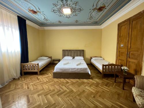 第比利斯Tiflisi Hostel的一间卧室设有两张床和蓝色的天花板