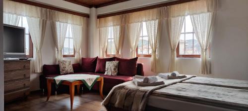 卡洛费尔查德卡旅馆的一间卧室配有沙发、一张床和窗户
