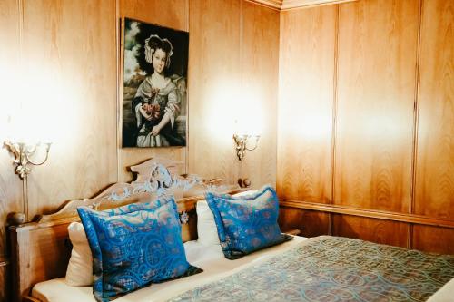 加尔米施-帕滕基兴安塔拉丝豪华酒店的一间卧室配有一张带蓝色枕头的床和一幅画