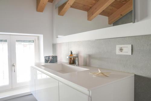 莱维科特尔梅Casa Riccardo的白色的厨房设有水槽和窗户