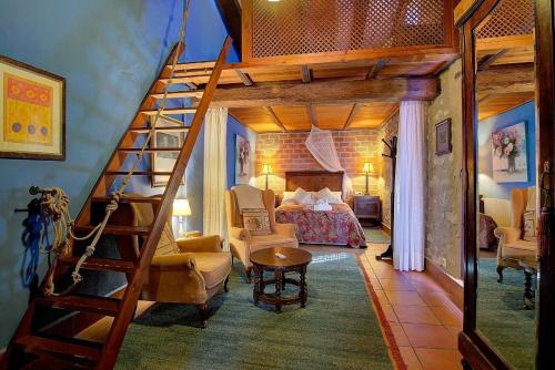 Benissiva卡萨加里纳拉酒店的一间卧室设有高架床和楼梯。