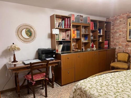 SonninoCasa fra gli ulivi di Giuseppe的一间卧室配有书桌和书架