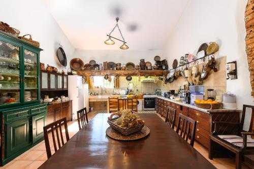 珀彻斯MONTE DAS AREIAS CASA DE CAMPO/PASSADIÇO/PATEO/RAMPA的一个带木桌和椅子的大厨房