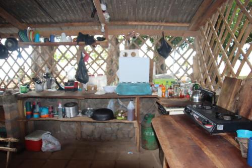 AltagraciaLa Sirenita - Ometepe的厨房配有炉灶和木桌。
