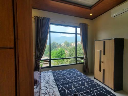 普卡Bobo Queen House 5 villa baba ( mountain view)的一间卧室设有一张床和一个大窗户