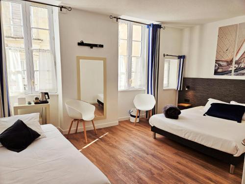 圣马丹德雷海港酒店的一间卧室配有两张床、两把椅子和镜子