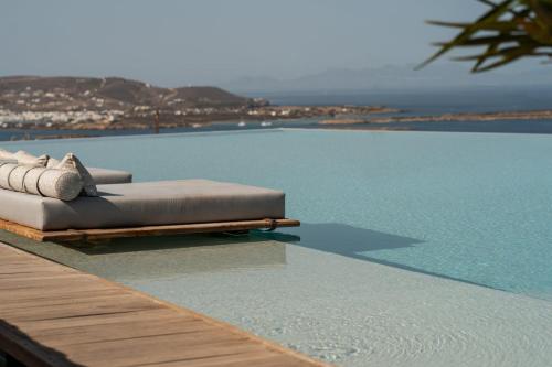 阿吉亚艾里尼帕罗Mythic Paros , Adults Only的桌子边带两个枕头的游泳池